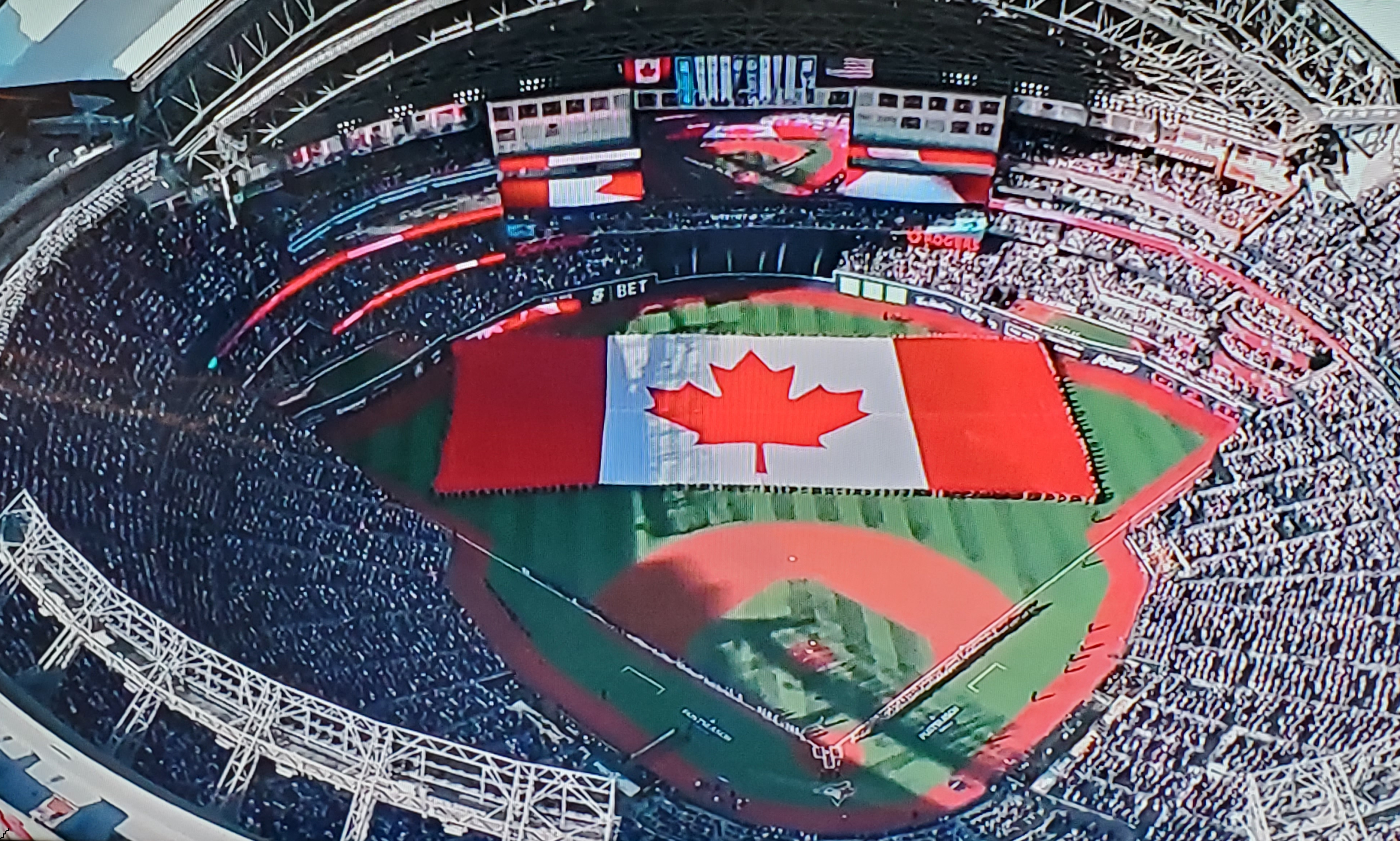 A giant Canadian flag on display in the outfield of the Blue Jays stadium.